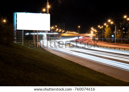 Large blank Billboard bilateral road night city with traces of the movement of machinery and light bulbs