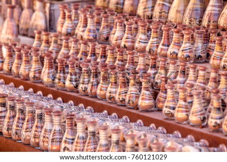 Bottles with specific colored sand picture , prepared by  bedouins  as souvenirs for visitors of Petra national park. Jordan