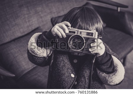 Young child photographed with a camera.