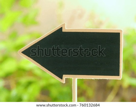 arrow shape of blackboard with blurred  background of gree trees for  environmental concept