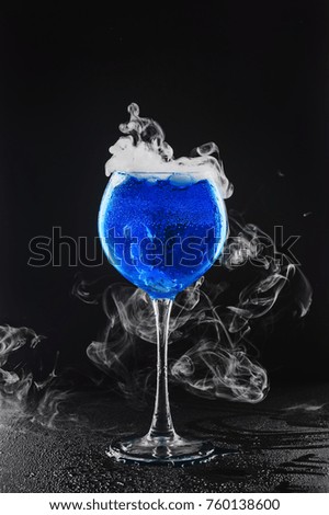 Blue cocktail, smoke effect, black background. Dry ice smoke
