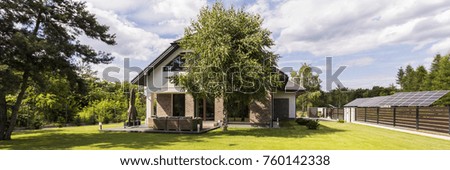 Panoramic shot of a residential area of the large house with a big tree 