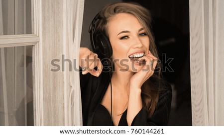 Portrait of a beautiful woman, who listen to the music with headphones at home early in the morning. Toned picture.