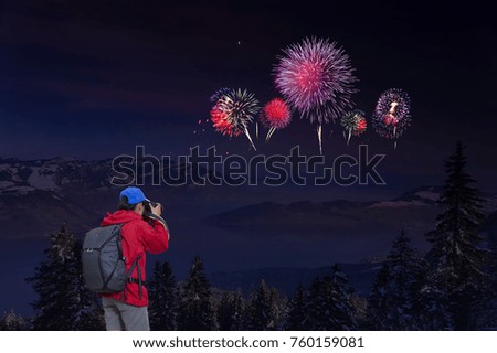 Woman enjoying fireworks celebration and taking photos on the mountain.