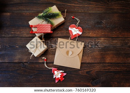 Christmas Composition set of gift kraft boxes with a decor of a fir-tree, sleds and heart on wooden background. Flat lay, top view photo mockup