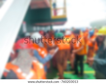 Blurred background abstract to article of offshore oil rig personnel practice emergency mustering drill at offshore work barge