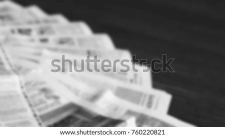 Lots of old newspapers on wooden table. Background texture, side view, blurred