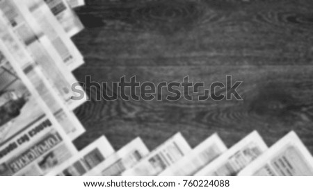 Lots of old newspapers on wooden table. Background texture, top view, blurred