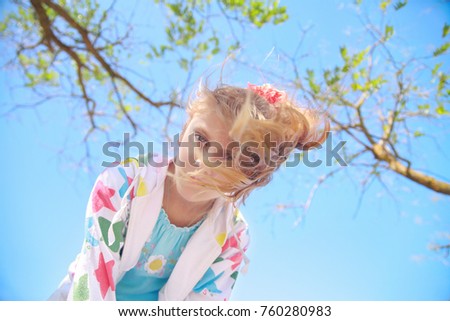 Little girl in the nature looks at the camera top down