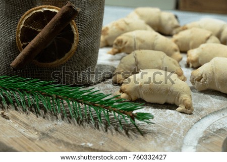 croissants with homemade jam lying on a wooden board rolled with flour   with green spruce 