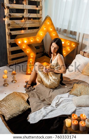 Girl in the interior with Christmas decoration, candles, lights
