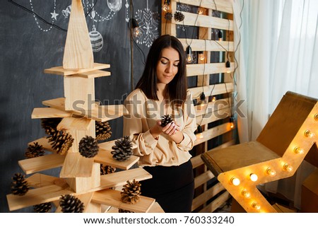 Girl in the interior with Christmas decoration, candles, lights