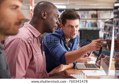 Mature Male Student With Tutor Learning Computer Skills Royalty-Free Stock Photo #760341478