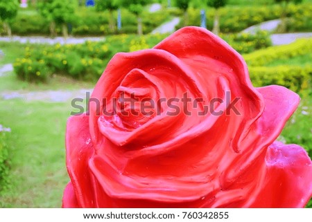 Red rose statue in the garden. This image was blurred or selective focus.