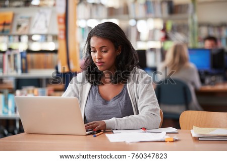 Mature Female Student Working On Laptop In College Library