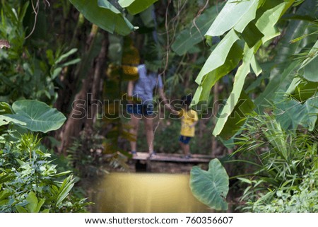 Riverside nature with blurred images of mother and daughter behind in Thailand.