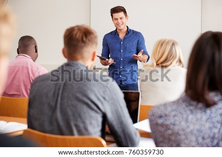 College Tutor With Digital Tablet Teaches Mature Students Royalty-Free Stock Photo #760359730