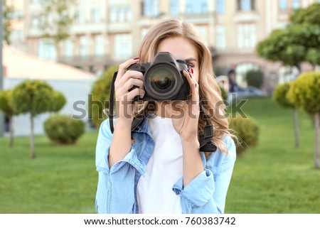 Young female tourist taking photo outdoors