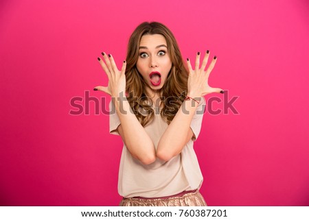 Picture of excited cute shocked woman standing isolated over pink wall background. Looking camera.
