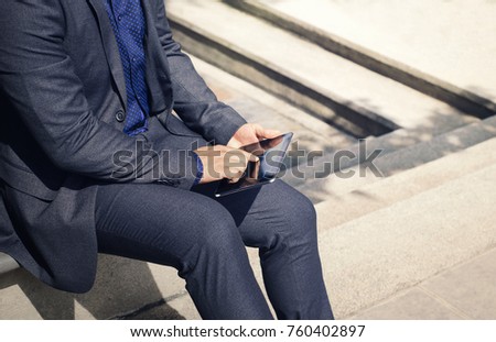 Businessman hand using tablet device outdoor