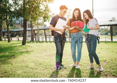 A group of young or teen asian student in university smiling and reading the book and look at the tablet or labtop computer in summer holiday. Royalty-Free Stock Photo #760414237