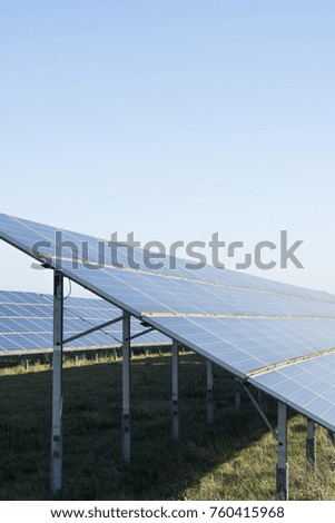 Large row of solar panels on a bright sunny day