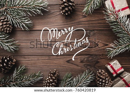 Brown wood background. Fir branches, decorative cones. Message space for Christmas and New Year. Gifts for xmas. Greeting card. Xmas and Happy New Year composition. Flat lay, top view Royalty-Free Stock Photo #760420819