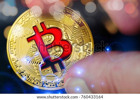 Golden bitcoins (virtual coins) in a hand with bokeh