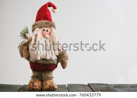 New year decoration. Plush Santa Toy on black woodden background
