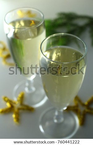 Christmas sparkly glasses of champagne on bright background with gold stars