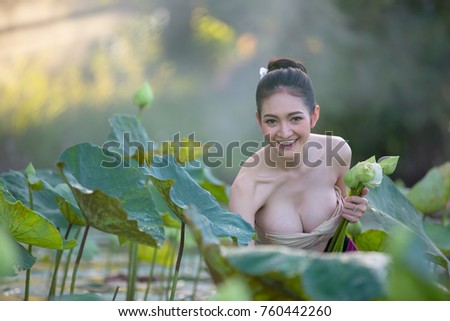 Asian woman harvest lotus flower in the garden