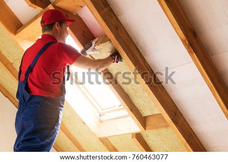 house attic insulation - construction worker installing rock wool in mansard wall Royalty-Free Stock Photo #760463077