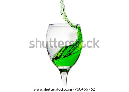 Wineglass with splashing drops of green alcohol cocktail - motion freeze close-up picture isolated on the white background.
