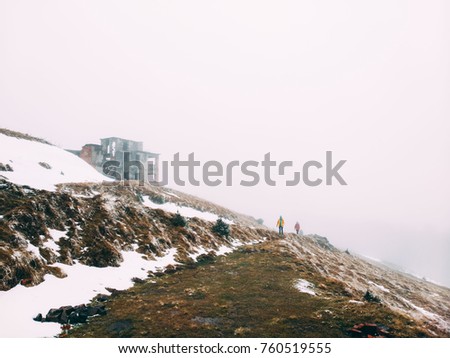 Winter picture of a hiker walking towards the abandoned dairy ruins. Mountain valley Borzhava