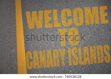 asphalt road with text welcome to canary islands near yellow line. concept