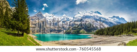 Amazing tourquise Oeschinnensee with waterfalls, wooden chalet and Swiss Alps, Berner Oberland, Switzerland. Royalty-Free Stock Photo #760545568