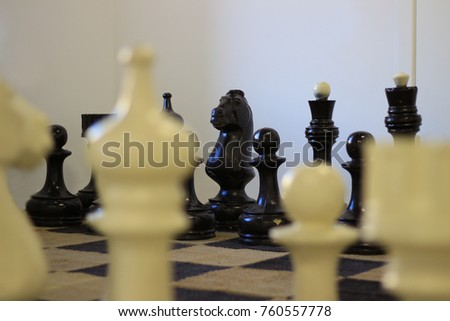 A huge chessboard and figures on a white background.