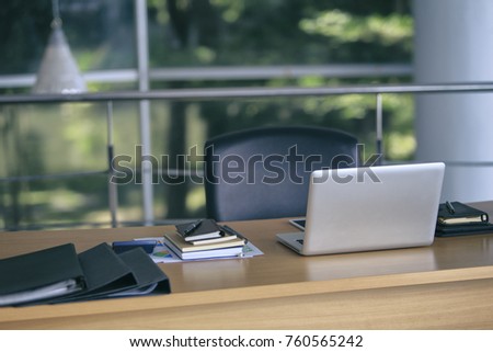 wooden office desk with Laptop, graph, and report paper