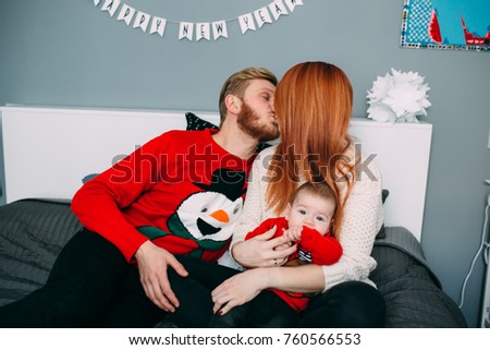 Happy family with newborn baby on the bed in the room
