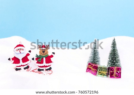 A Santa Claus and a reindeer with gifts in the snow