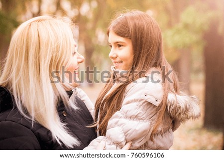 Young mother and daughter enjoying together outdoors in a beautiful autumn day. A little girl looks at her mother with love. Happy loving family. mothers Day.High ISO
