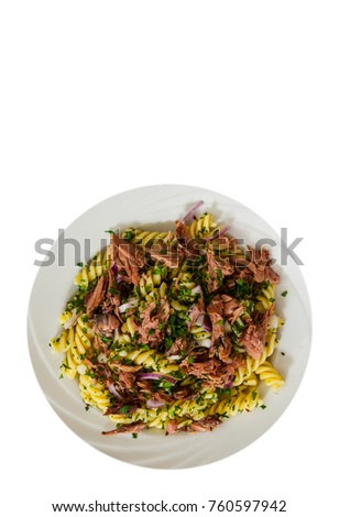 pasta fusilli salad with tuna and onion in white plate with copy space. top view. isolated on white