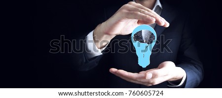 businessman holding an electric light bulb