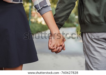 Multiethnic couple in love. Unrecognizable african-american man and asian woman walk in park, holding hands, closeup, copy space Royalty-Free Stock Photo #760627828