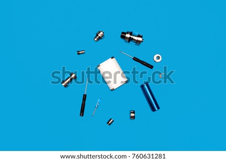 vape accessories on blue background in center