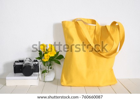 Yellow shopping bag with camera on table. Hello Monday and lifestyle concept