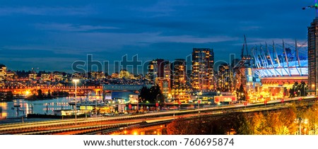Shooting from the top, center in a big metropolis at night with traffic lights, a car, skyscrapers and office by the ocean and ships, sunset and clouds, traffic and street lighting