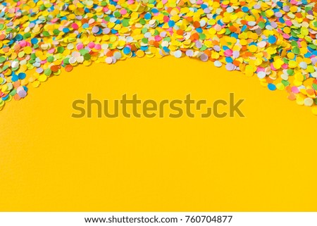 Colorful Confetti in front of orange Background. 