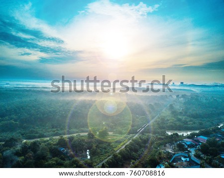 Aerial view of village plantation with lens flare.