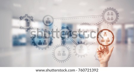 Close of woman hand touching gears on screen with finger and office at background